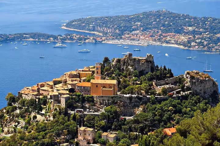 Aerial view of Èze village perched on a cliff overlooking the Mediterranean Sea, a highlight of Cannes private shore excursions.