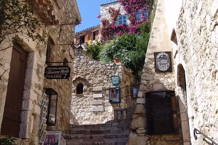 Charming stone pathway adorned with vibrant flowers in the historic village of Eze, ideal for a private guided tour.