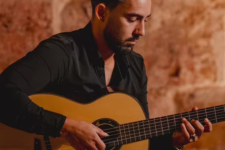 A musician playing a classical guitar during a Fado performance in Lisbon, highlighting Portugal's rich cultural heritage.