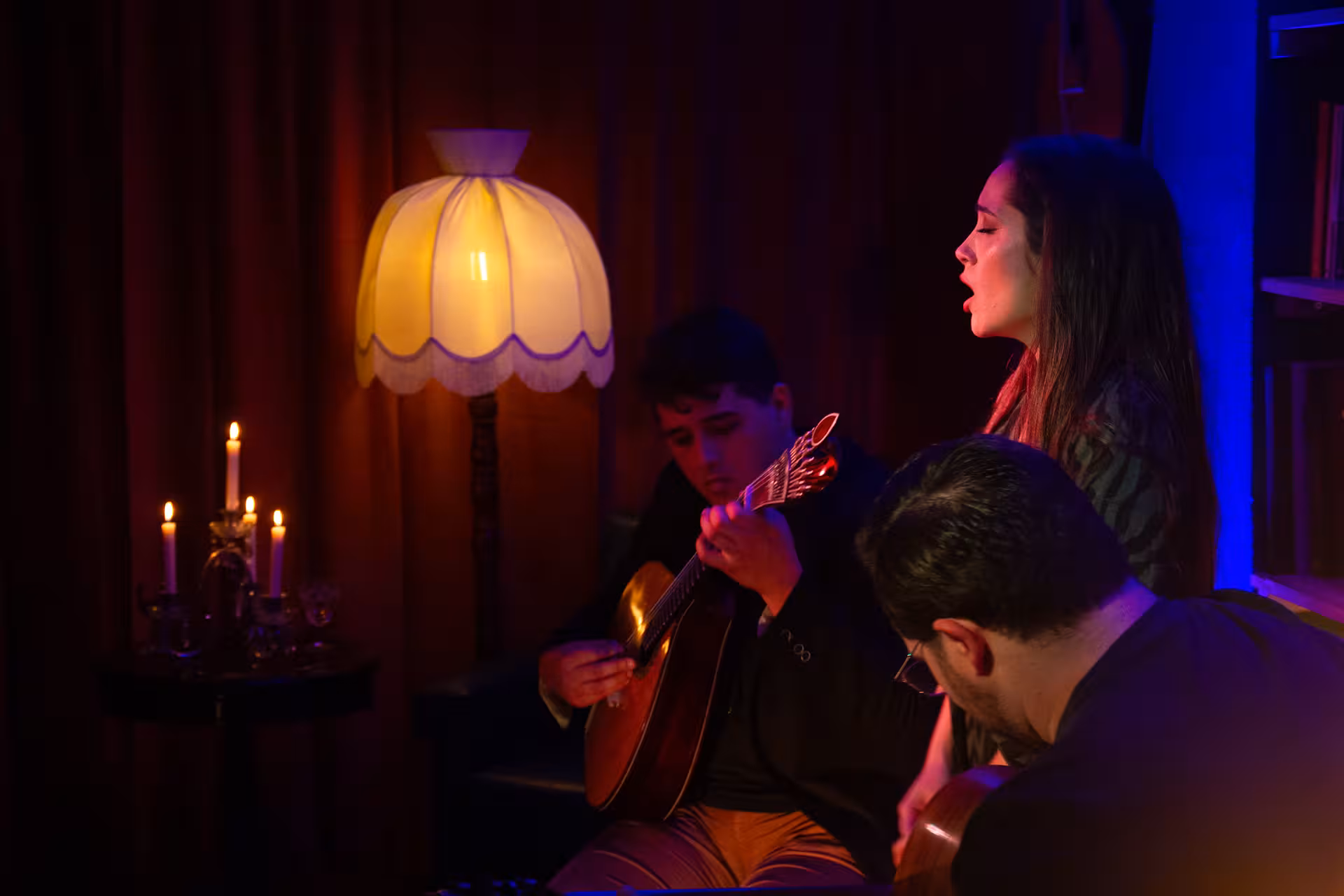 Intimate Fado performance with singer and guitarists in a cozy, candlelit setting showcasing traditional Portuguese music.