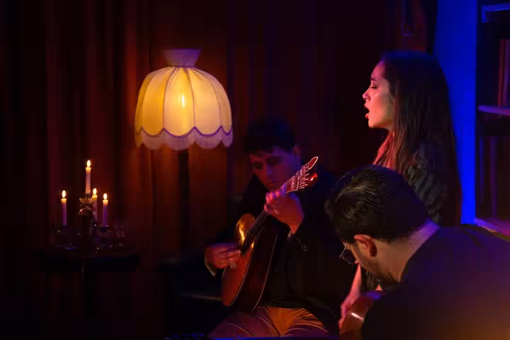 Fado singer and guitarists perform in a cozy Lisbon venue, creating an authentic Portuguese music experience.