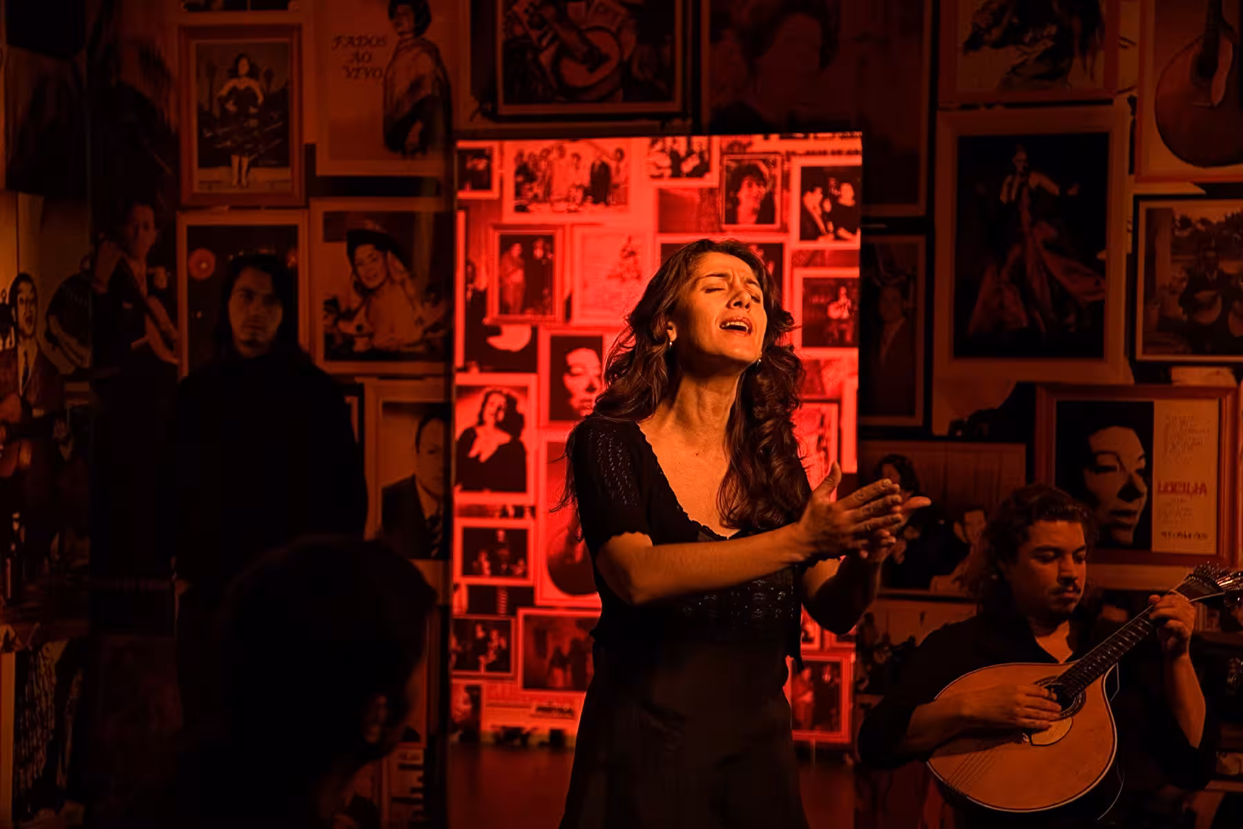 Fado singer passionately performing in a cozy Lisbon venue during the Fado Night Tour with Dinner.