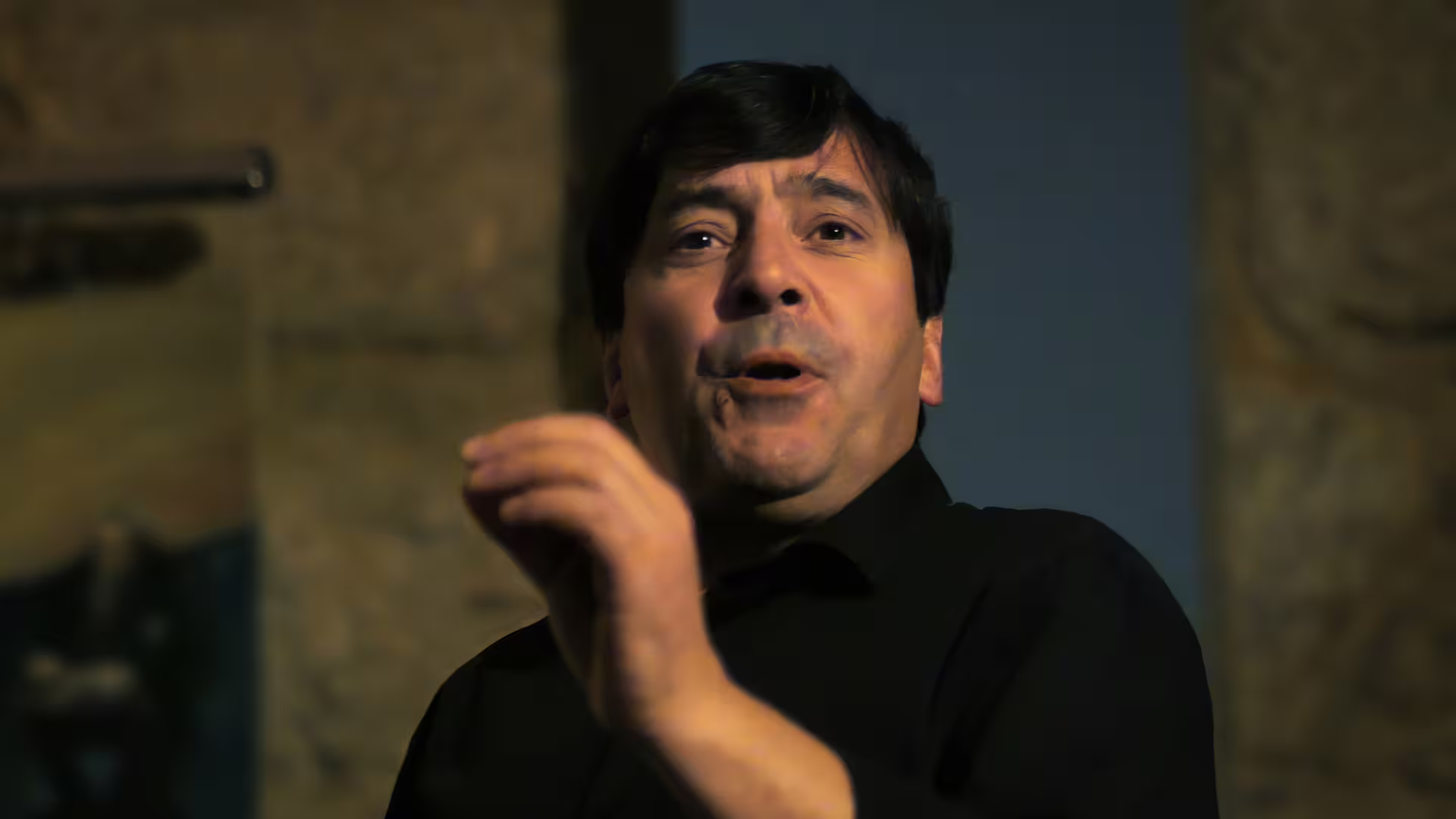 Image of a male Fado singer performing with intensity at a local restaurant, part of Cooltour Oporto's Fado Dinner Show with Night Tour