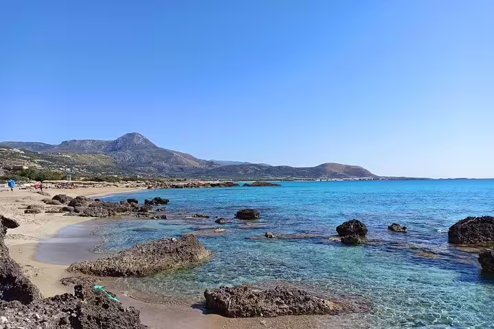 Panoramic view of Falassarna Beach with turquoise waters and distant mountains, ideal for a day trip from Chania.