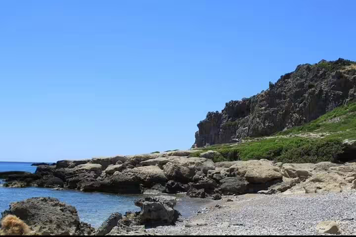 Explore the rugged coastline of Falassarna Beach with crystal-clear waters and rocky cliffs on a sunny day near Chania.
