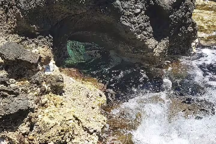 Natural rocky arch with clear water flow, showcasing the rugged beauty of Falassarna's coastline near Chania.