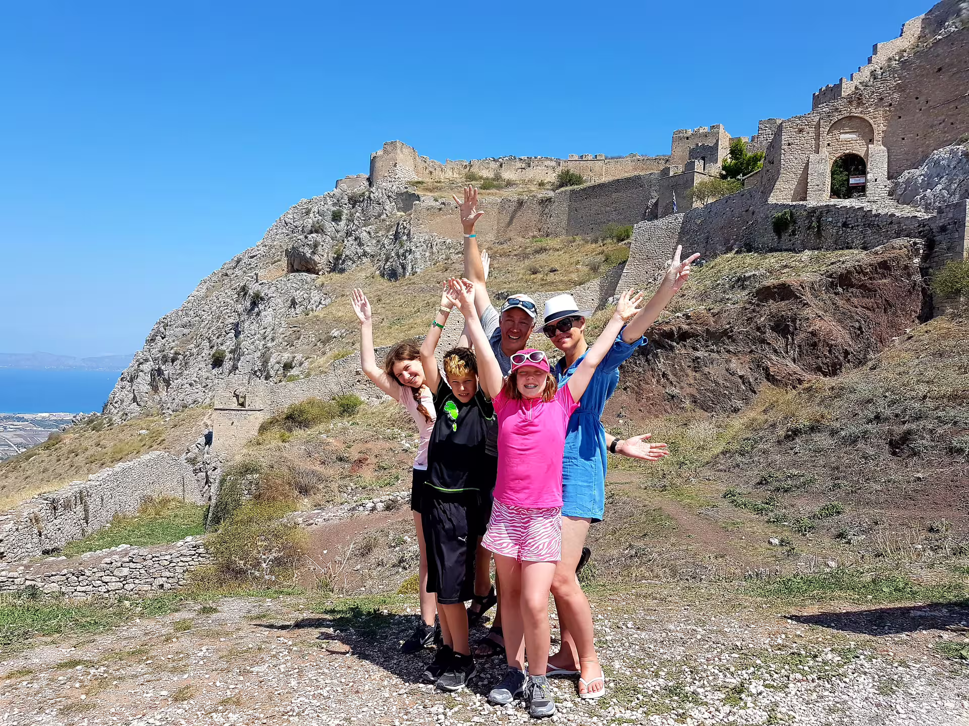 Family celebrates at Acrocorinth fortress on private Ancient Corinth biblical tour from Athens with sea views