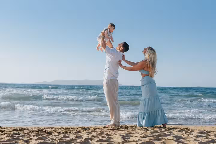 Family enjoying a private beach photoshoot in Heraklion, capturing joyful moments by the sea under a clear blue sky.