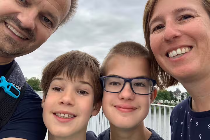 Family selfie on a Bordeaux riverside walkway while playing a self-paced e-scavenger hunt sightseeing game