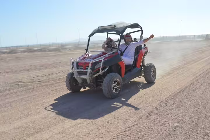 Family buggy racing across Sinai desert near Sharm El Sheikh, dust trail on off-road safari adventure