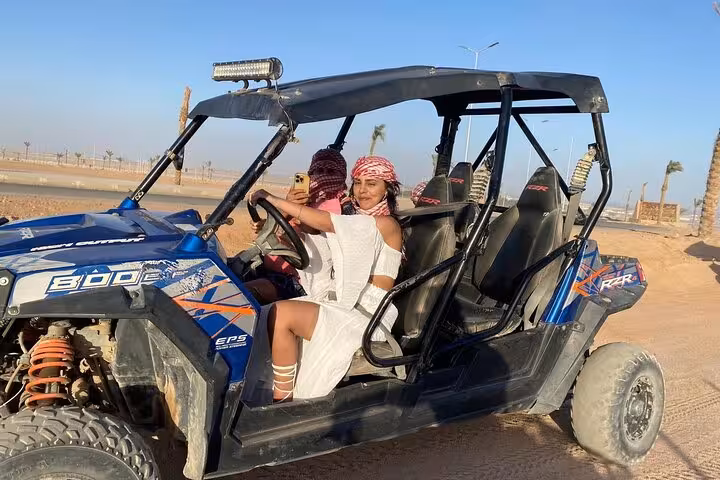 Woman driving family buggy in Sharm El Sheikh desert, private safari ride with safety belts and shade roof