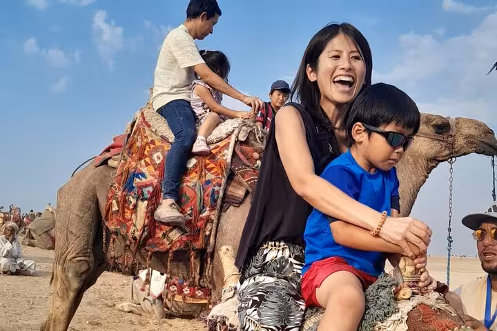Family camel ride at Giza Pyramids during 3-day Cairo all-inclusive tour with Egyptian Museum and churches