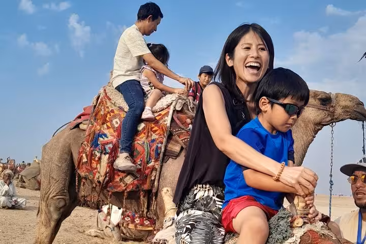 Family camel ride at Giza Pyramids on all-inclusive guided tour to Giza, Saqqara and Memphis with local guide