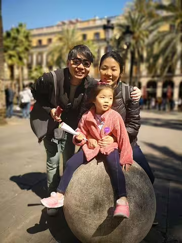 Family enjoying a sunny day at a plaza in Barcelona, perfect for a private tour with churros, hot chocolate, and games.