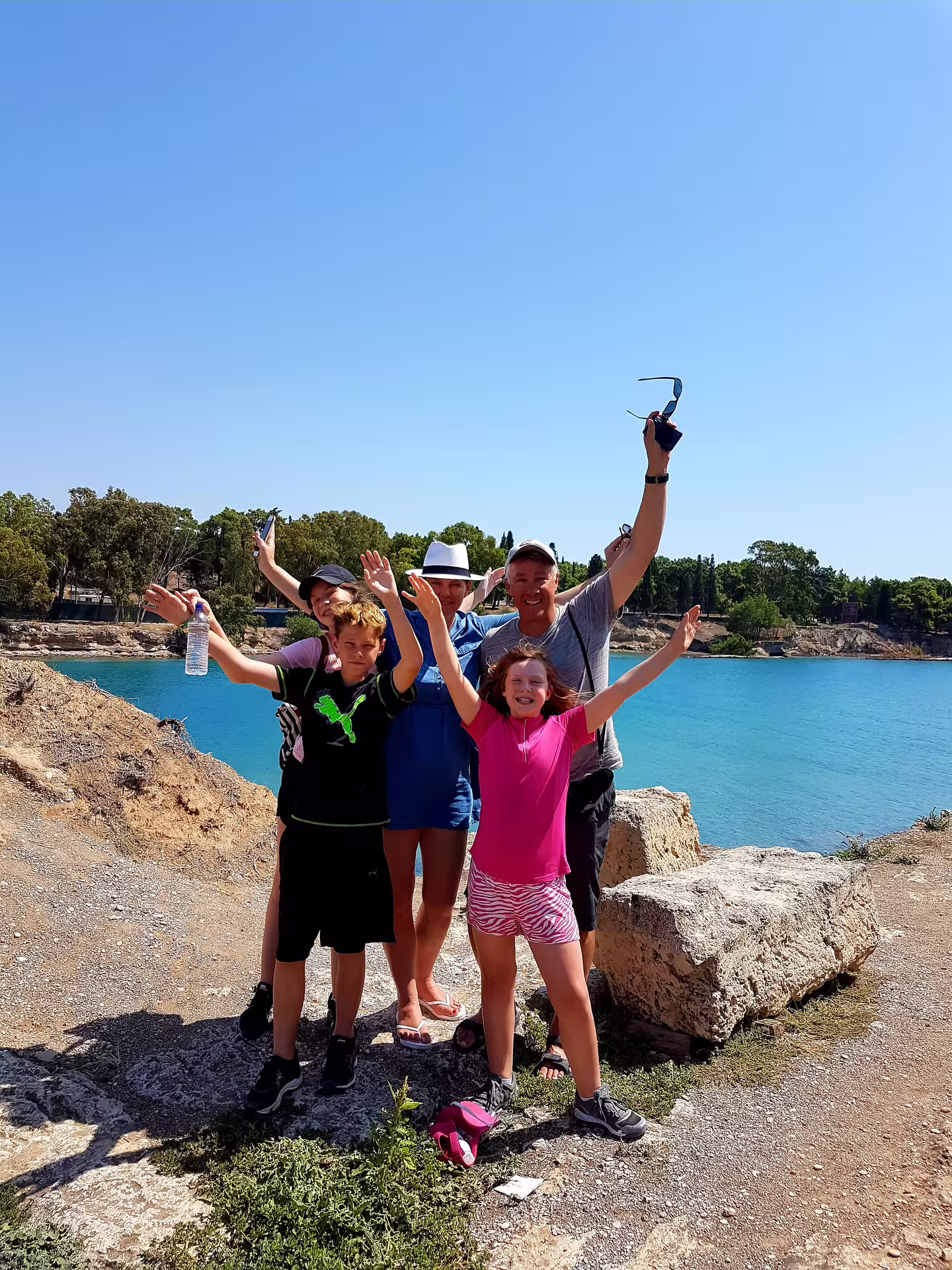 Family celebrating by the blue Corinth Canal viewpoint on a private Athens to Corinth and Mycenae tour