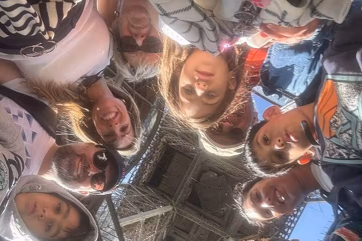 Family selfie under the Eiffel Tower on a private Paris half-day tour with guide and Seine cruise add-on