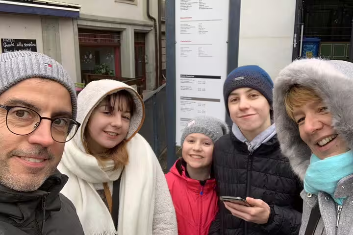 Family selfie during a Fribourg scavenger hunt and sights self-guided tour, checking clues on a smartphone