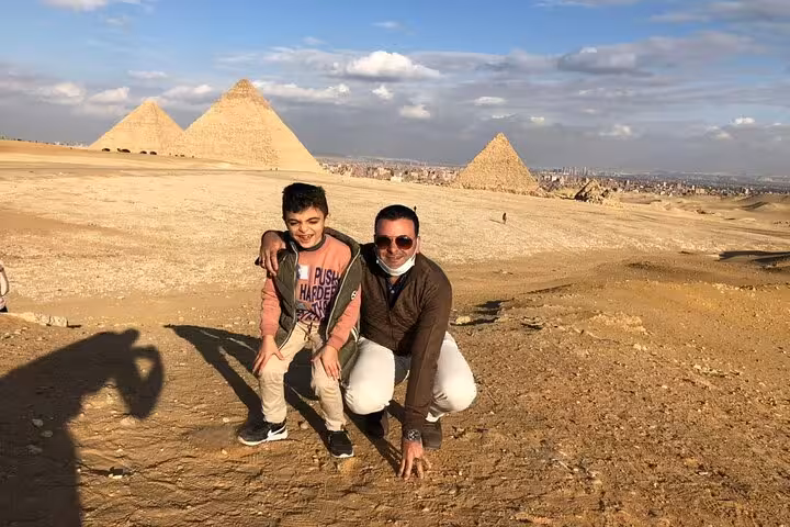 Family photo at the Giza Pyramids with desert panorama, ideal for a private Cairo pyramids day tour