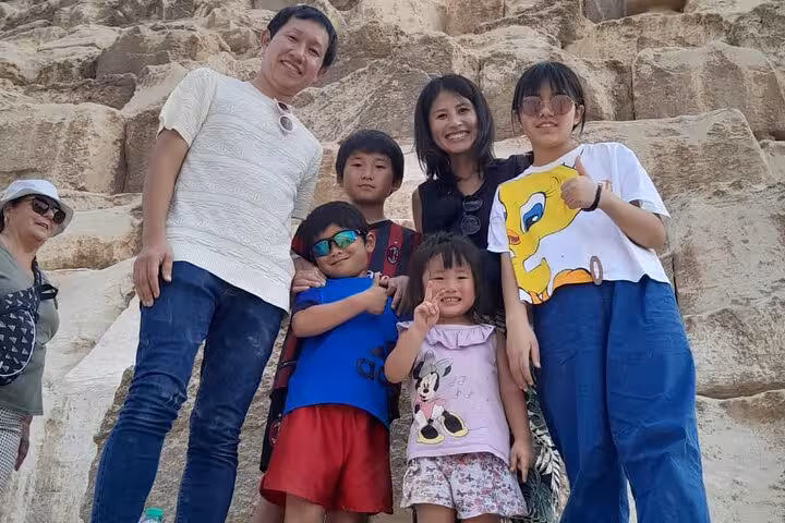 Family photo at the base of the Giza Pyramids during Cairo airport layover tour with private guide