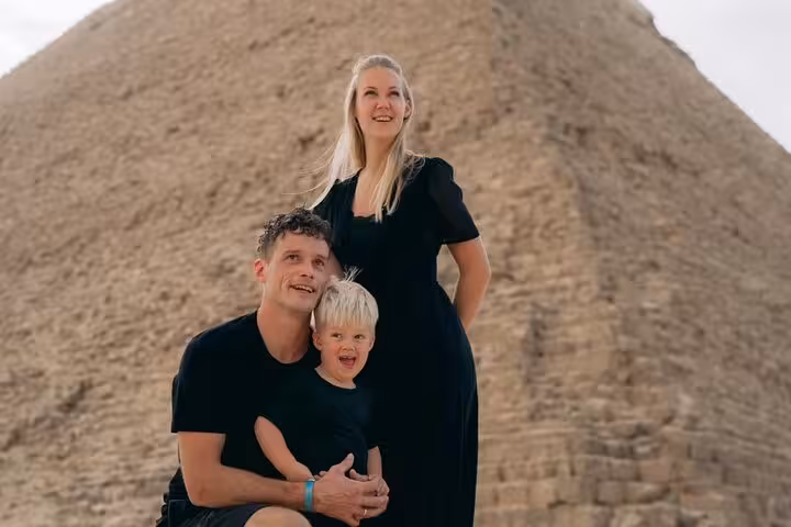 Family photo at Giza Pyramids, Cairo, on a 3-day guided tour with museum visit and free hostel stay