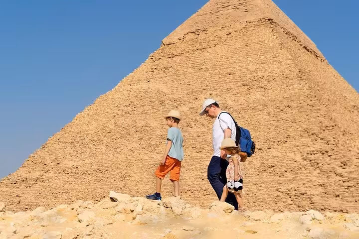 Family walking near the Great Pyramid of Giza on Discover Cairo tour from Hurghada, pyramids and Sphinx