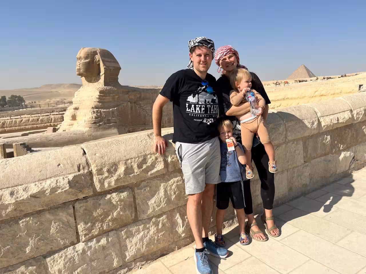Family by the Great Sphinx and Giza Pyramids on Cairo camel ride tour, with lunch and guided sightseeing