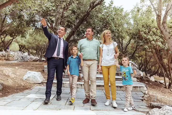 Happy family with a guide exploring scenic paths on a private day trip from Athens to Meteora.