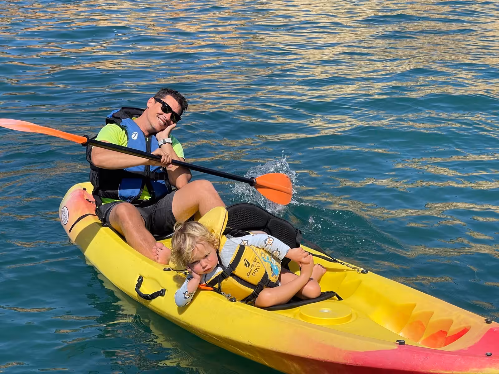 Family kayaking in Lagos Algarve on Ponta da Piedade cave tour, tandem kayak on calm Atlantic water
