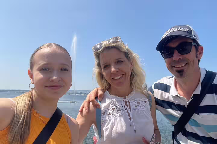 Family photo by Lake Zug with fountain views, taking a Zug scavenger hunt and sights self-guided tour