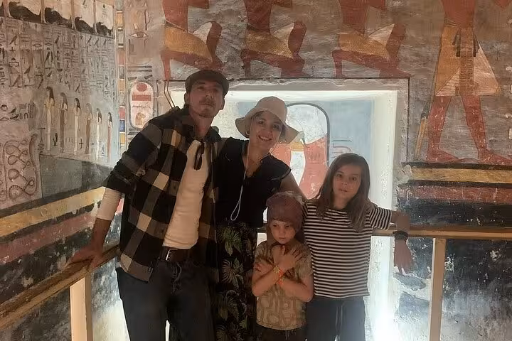 Family enjoying the vibrant ancient wall art inside a Luxor tomb on a private guided tour.