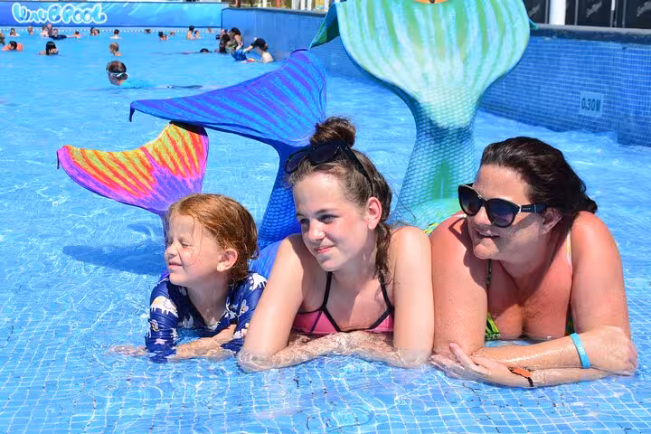 Family enjoying a colorful mermaid photoshoot experience in a pool in Hersonissos, perfect for unique holiday memories.