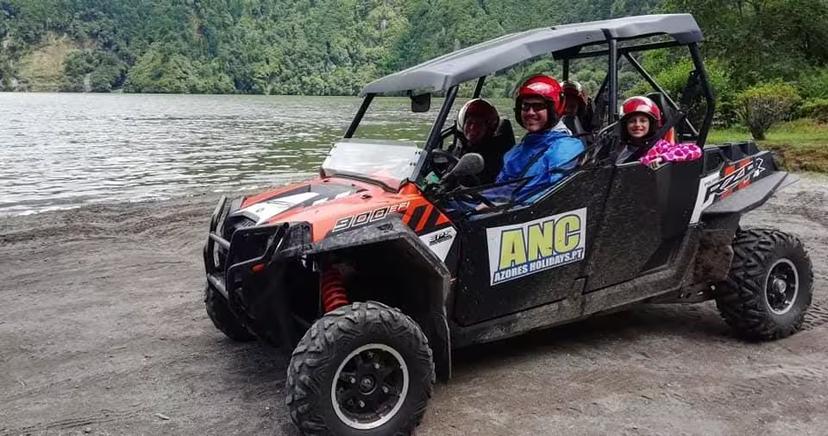 Family in helmets driving off-road buggy by scenic Azores lake on full-day coast to coast adventure tour with lunch included