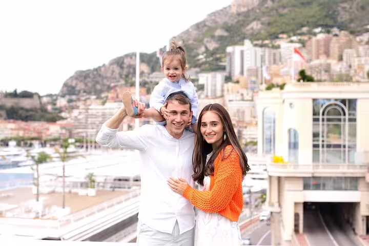 Happy family with child enjoying a photo session overlooking the beautiful Cannes cityscape and harbor.