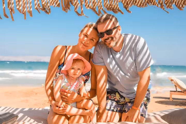 Happy family relaxing under a beach canopy in Heraklion, capturing cherished memories on a sunny day.