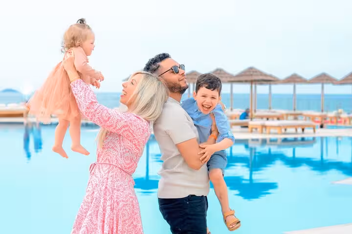 Joyful family by a pool, capturing precious moments with the sea as a backdrop in a Heraklion photoshoot.
