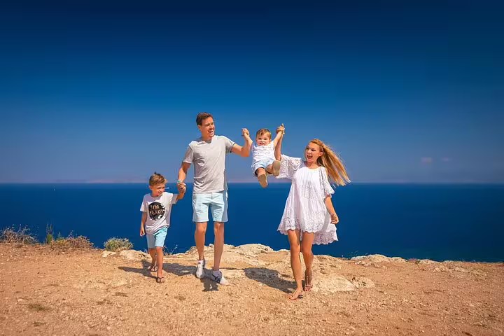 Family walking joyfully on a cliff in Rhodes with stunning sea views, perfect for a memorable photoshoot experience.