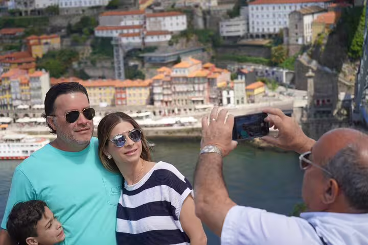 Family enjoys scenic view of Porto's colorful riverside during 3-day Lisbon to Porto & Douro Valley private tour.