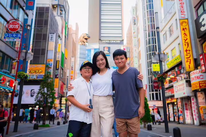 Family portrait in Shinjuku Tokyo with private vacation photographer, neon city street backdrop and landmarks