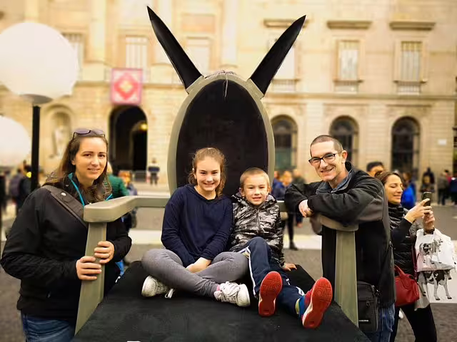 Family enjoying a private tour in Barcelona with churros, hot chocolate, and fun games in a vibrant city square setting.