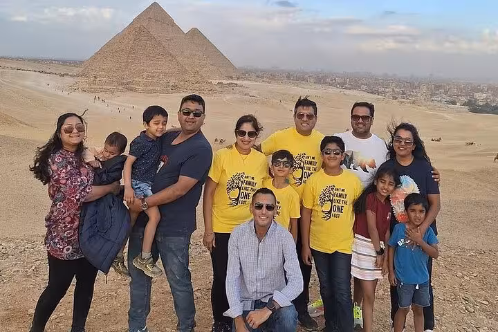 Family group at the pyramids in Egypt, part of a private tour including the Egyptian Museum and bazaar visit.