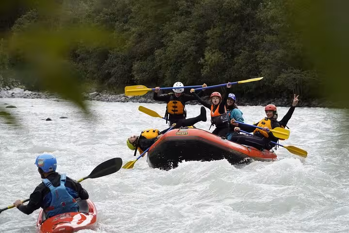Excited family navigating Engadin's thrilling rapids, showing teamwork and joy on a vibrant rafting trip.