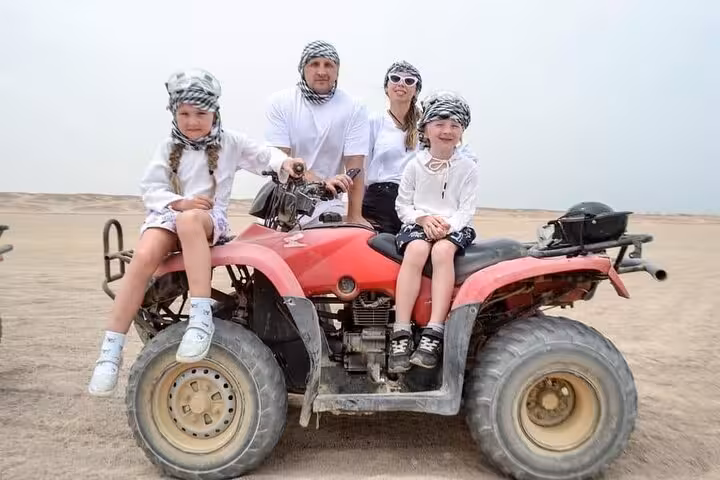 Family posing on red ATV quad bike in Sharm El-Sheikh desert, Sinai dunes adventure tour photo