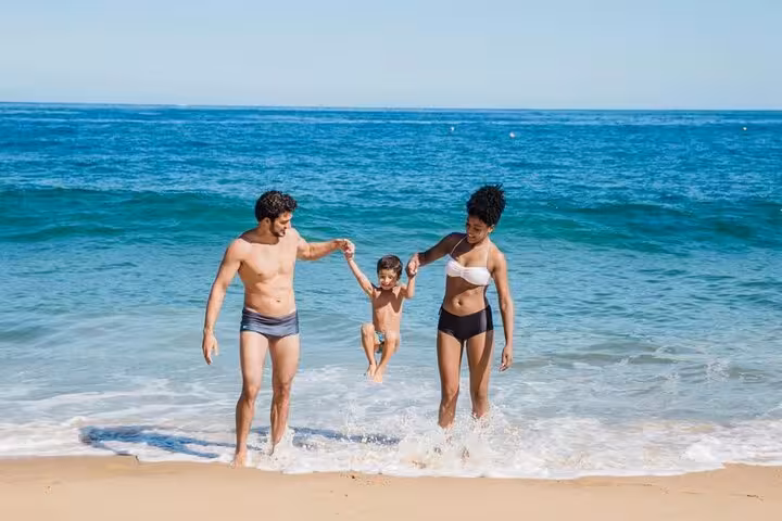 Family playing in the Red Sea surf near Sharm El-Sheikh, beach time on Ras Mohamed half-day tour excursion