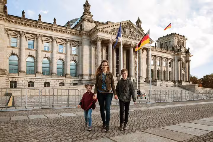 Family photo shoot at the Reichstag building in Berlin with German flags, private travel photographer tour
