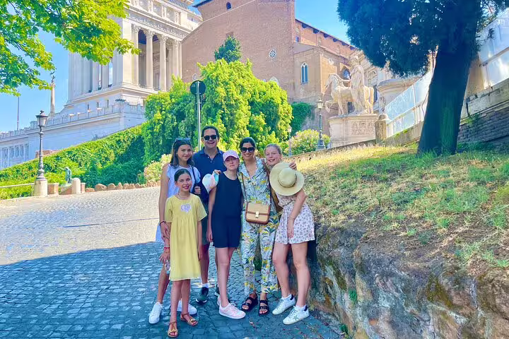 Smiling family on a Rome kids friendly guided tour, posing by ancient Capitoline Hill monuments and cobbled streets in summer
