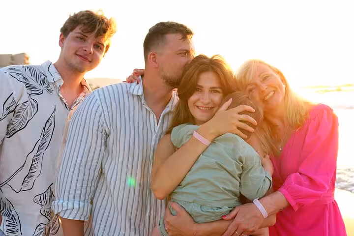 Family enjoying sunset moments on a Hersonissos beach during a private photoshoot, capturing joyful and loving memories.