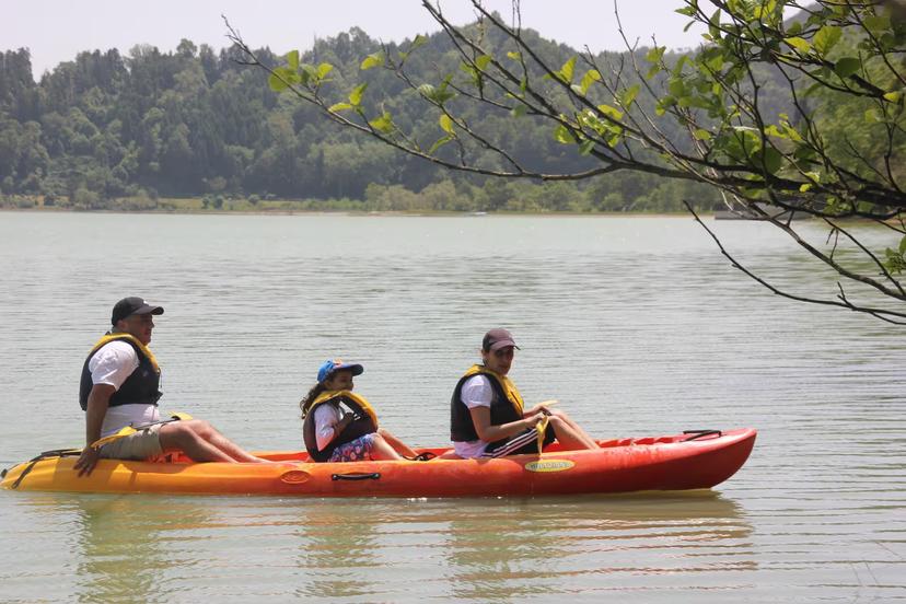 Family paddles a tandem canoe on a calm lake, half-day canoeing tour with transportation and life jackets