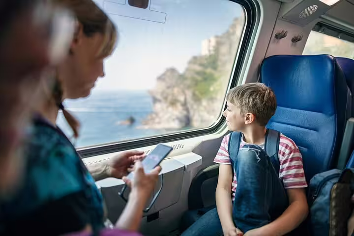 Family on train from La Spezia to Cinque Terre admiring Ligurian Sea views during private guided coastal tour