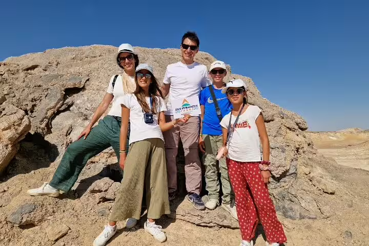 Family photo on limestone rock in Egypt’s White Desert, part of a private 4-day Bahariya Oasis tour