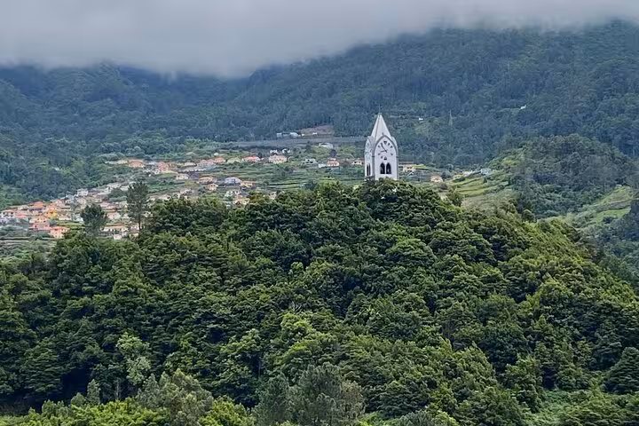 White hilltop church above lush West Madeira valley, panoramic viewpoint on Fanal Forest skywalk 4x4 expedition